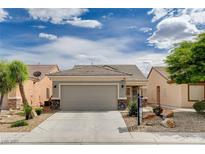 Charming single-story home featuring a two-car garage and desert landscaping with rock accents at 2621 Ground Robin Dr, North Las Vegas, NV 89084