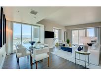 Bright living and dining area features floor-to-ceiling windows and stylish, contemporary furnishings at 2700 Las Vegas Blvd # 2303, Las Vegas, NV 89109