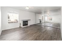 Bright living room features sleek hardwood floors, a modern fireplace and large mirror wall at 5025 Starfinder Ave, Las Vegas, NV 89108