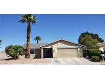 Charming single-story home featuring a well-manicured front yard with mature palm trees and desert landscaping at 7104 Carrondale Way, Las Vegas, NV 89128