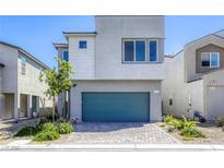 Modern two-story home with gray stucco, blue-green garage door, and landscaped front yard at 9772 Alpine Style Dr, Las Vegas, NV 89166