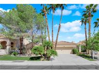 Charming single-story home with well-manicured front yard, lush greenery, and a two-car garage, offering great curb appeal at 1848 Indian Bend Dr, Henderson, NV 89074