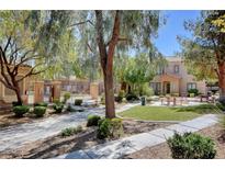 A beautiful community area with picnic tables, lush greenery, and a refreshing pool at 2141 Hussium Hills St # 102, Las Vegas, NV 89108