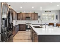 This kitchen features stainless steel appliances, dark wood cabinets, white quartz countertops and hardwood floors at 3096 Cipro Ave, Las Vegas, NV 89141
