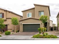 Charming two-story home featuring a two-car garage and a well-maintained front yard with young trees and mature landscaping at 7721 Sheliak St, North Las Vegas, NV 89084