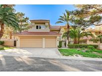 Inviting two-story home featuring a red tile roof, mature landscaping and a spacious driveway leading to a two-car garage at 8051 Castle Pines Ave, Las Vegas, NV 89113