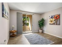 Well-lit living area featuring hardwood floors, a sliding glass door, and tasteful decorative accents at 1830 N Buffalo Dr # 1031, Las Vegas, NV 89128