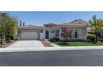Charming single-story home featuring a tile roof, neutral stucco, arched entry, and well-manicured landscaping at 2080 Orchard Mist St, Las Vegas, NV 89135