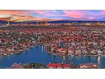 Stunning aerial view of a lakeside community with the city skyline and a colorful sunset in the background at 3080 Yankee Clipper Dr, Las Vegas, NV 89117