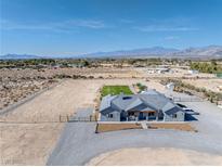 Expansive aerial view of a single story home featuring desert landscaping and mountain views in the background at 3880 Rudek St, Pahrump, NV 89061
