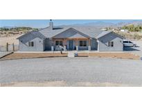 Charming single-story home featuring a covered front porch and desert landscaping at 3880 Rudek St, Pahrump, NV 89061