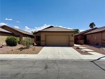 Charming single-story home with a two-car garage and low maintenance desert landscaping at 4017 Gliding Gulls Ave, North Las Vegas, NV 89084