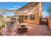 The backyard features an outdoor kitchen, fire pit, covered patio and privacy wall at 4133 Perfect Lure St, Las Vegas, NV 89129