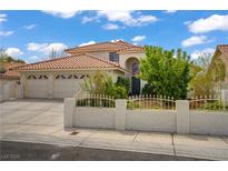 Charming single-Gathering home featuring a well-manicured front yard, a three-car garage, and a red tile roof at 5609 Red Bluff Dr, Las Vegas, NV 89130