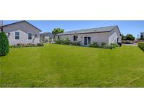 Sprawling backyard with lush lawn, landscaping, and access to the home through sliding glass doors at 790 Lone Pine Rd, Pahrump, NV 89048