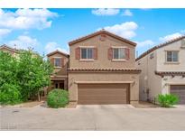 Charming two-story home with a two-car garage and desert landscaping under a bright blue, partly cloudy sky at 9024 Hazy Haven Ct, Las Vegas, NV 89149