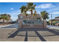 Two-story home with palm trees, gated entrance, and a long driveway at 131 Beesley Dr, Las Vegas, NV 89110