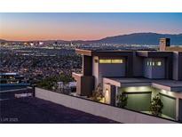 Modern home exterior with sleek design and a backdrop of the vibrant city skyline at dusk at 25 Rockstream Dr, Henderson, NV 89012