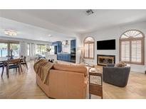 Bright, open living area featuring a fireplace, herringbone floors, and seamless flow into kitchen at 8924 Sail Bay Dr, Las Vegas, NV 89117