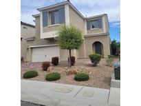 Two-story home featuring desert landscaping, muted exterior color scheme, attached two car garage, and blue shuttered windows at 9020 Tiffany Oaks Ave, Las Vegas, NV 89148