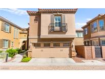 Inviting tan two-story home with a two-car garage and charming balcony on a sunny day at 11294 Corsica Mist Ave, Las Vegas, NV 89135