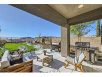 Relaxing covered back patio featuring a built-in grill, stylish furniture, and mountain views at 12532 Blissful Sky St, Las Vegas, NV 89138
