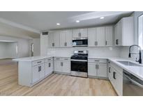 Well-lit kitchen with white cabinets, stainless steel appliances, and quartz countertops at 212 View Dr, Las Vegas, NV 89107