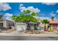 Charming single-story home featuring mature landscaping, a well-maintained lawn, and a two-car garage at 2377 Los Feliz St, Las Vegas, NV 89156