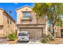 Two-story home featuring a tan exterior, a two-car garage, and a small landscaped front yard at 3568 Gloucester Gate St, Las Vegas, NV 89122