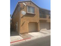 Tan two-story home featuring an attached garage, and a small upper balcony at 6158 Calm Breeze Ave # 101, Las Vegas, NV 89108