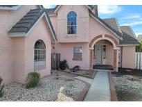 Charming two-story home with a unique archway entrance and a well-maintained front yard landscape at 6561 Avon Ct, Las Vegas, NV 89108
