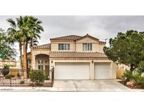 Charming two-story home featuring a tiled roof, three-car garage, and complemented by mature trees and desert landscaping at 8886 Blake Alan Ave, Las Vegas, NV 89147