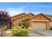 Charming single-story home with a two-car garage, desert landscaping, and a terracotta-colored exterior at 900 Royal Plum Ln, Las Vegas, NV 89144