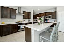 This spacious kitchen features dark wood cabinetry, white countertops, and a stainless steel oven and range hood at 4630 Adonis Blue St, North Las Vegas, NV 89031