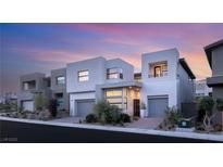 Contemporary home exterior showcasing clean lines, neutral color palette, and well-manicured landscaping under a beautiful sunset sky at 10752 Patina Hills Ct, Las Vegas, NV 89135
