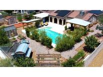 Inviting backyard oasis featuring a sparkling pool, covered patios, and lush greenery for ultimate relaxation at 197 Ebb Tide Cir, Las Vegas, NV 89123