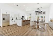 Bright eat-in kitchen features an island with bar seating, stainless appliances, and modern chandelier at 4117 Sinew Ct, Las Vegas, NV 89129