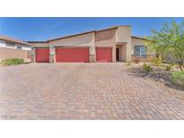 Charming single-story home featuring a three-car garage and brick-paved driveway at 10266 Sweet Holly Pl, Las Vegas, NV 89149