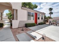 Inviting single story home featuring a red door, desert landscaping, a covered arch, and outdoor seating at 1116 Piazza Telle, Henderson, NV 89052