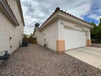 Tan home featuring a two car garage, gravel yard, and an orange tiled roof at 2571 Swans Chance Ave, Henderson, NV 89052