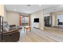 Modern living room with sliding glass doors, gray sofa, and stainless steel refrigerator at 2606 S Durango Dr # 260, Las Vegas, NV 89117