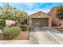 Charming single-story home featuring a two-car garage, desert landscaping, and flowering tree at 3005 Dotted Wren Ave, North Las Vegas, NV 89084