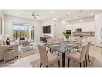 Bright, open-concept dining area with modern glass table and seating, seamlessly flowing into the kitchen and living space at 354 Spotted Dove St, Las Vegas, NV 89138