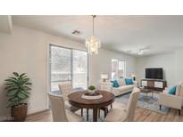 Bright living room with dining area, wood floors, modern lighting and sliding glass door to a private backyard at 632 Twilight Blue Ave, North Las Vegas, NV 89032