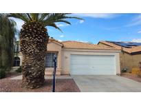 Charming single-story home with a two-car garage and a well-maintained front yard with gravel and mature palm tree at 7053 Magic Moment Ln, Las Vegas, NV 89119