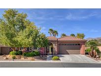 Charming single-story home featuring a tile roof, landscaped yard, and a two-car garage, set against a backdrop of a bright blue sky at 7204 Royal Melbourne Dr, Las Vegas, NV 89131