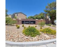 Lamplight Cottages community entrance sign with landscaping and view of some buildings at 7589 Grassy Bank St, Las Vegas, NV 89139