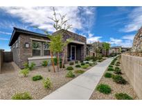 Charming single-story home featuring stone accents, a well-manicured yard, and a welcoming walkway at 897 Woodburn Ln, Las Vegas, NV 89138