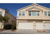 Beige two-story townhome featuring a multi-car garage and well-maintained landscaping at 9343 Leaping Deer Pl # 103, Las Vegas, NV 89178
