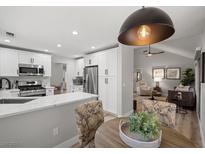 Bright kitchen featuring white cabinets, stainless steel appliances, quartz countertops, and modern lighting at 9540 Eagle Valley Dr, Las Vegas, NV 89134